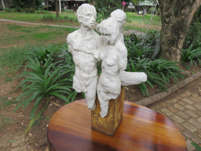 Decorative art piece - Three moulded ceramic nude figures on oxidised steel base