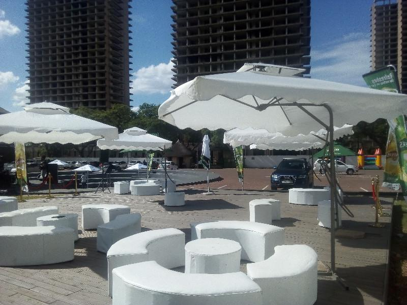 Garden umbrellas hire with round set up ottomans. Outdoor furniture hire. Couches and ottomans hire.