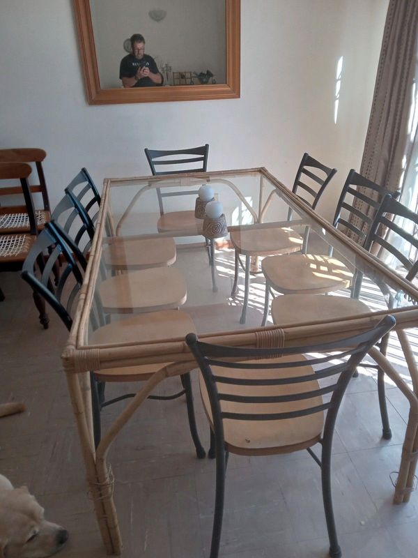 Glass and baboo table with 8 chairs for sale.