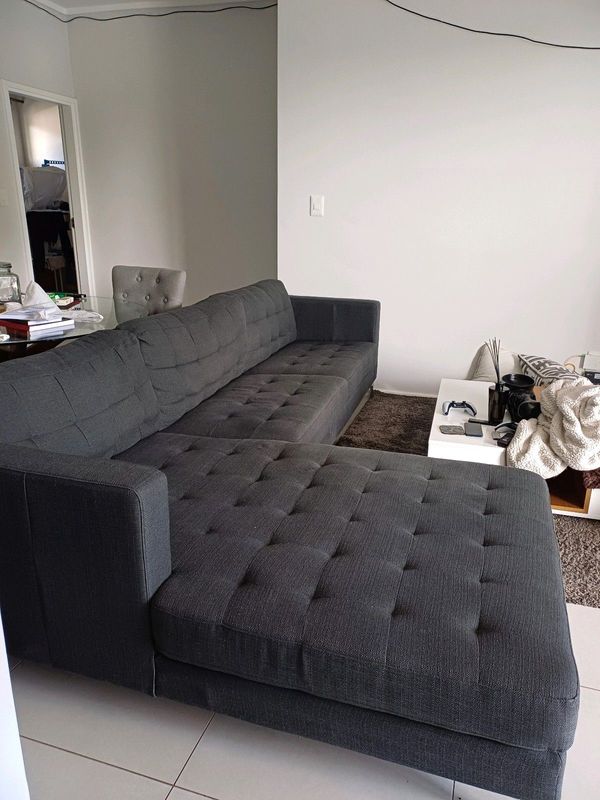 A neat nice Grey Couch is for in Sandton, 0848 120008.