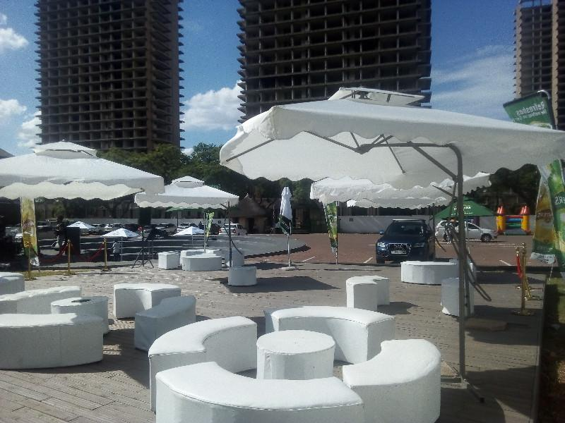 Garden umbrellas and round set ottomans hire and decor. Chillas lounge decor set up with couches.