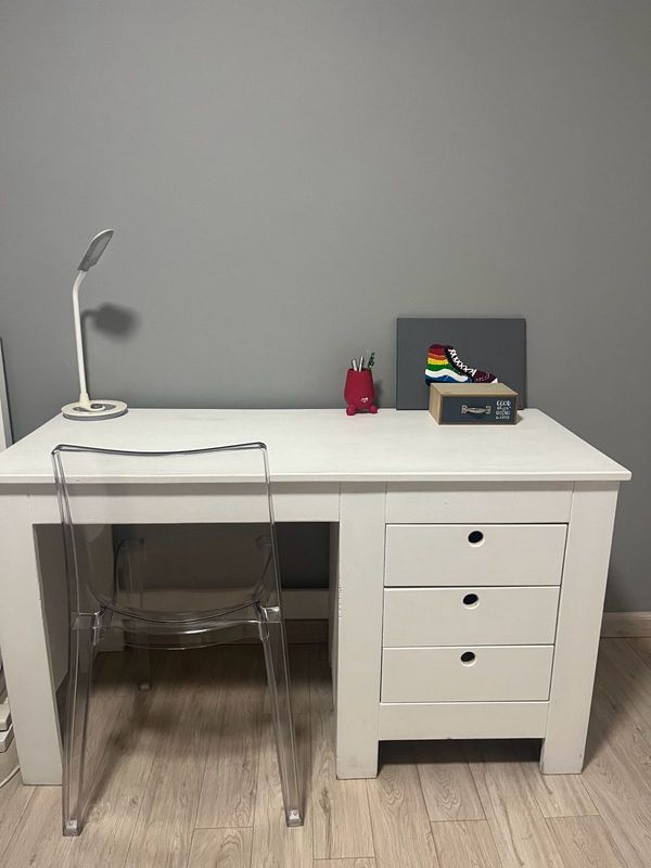 White wooden desk and transparent plastic chair