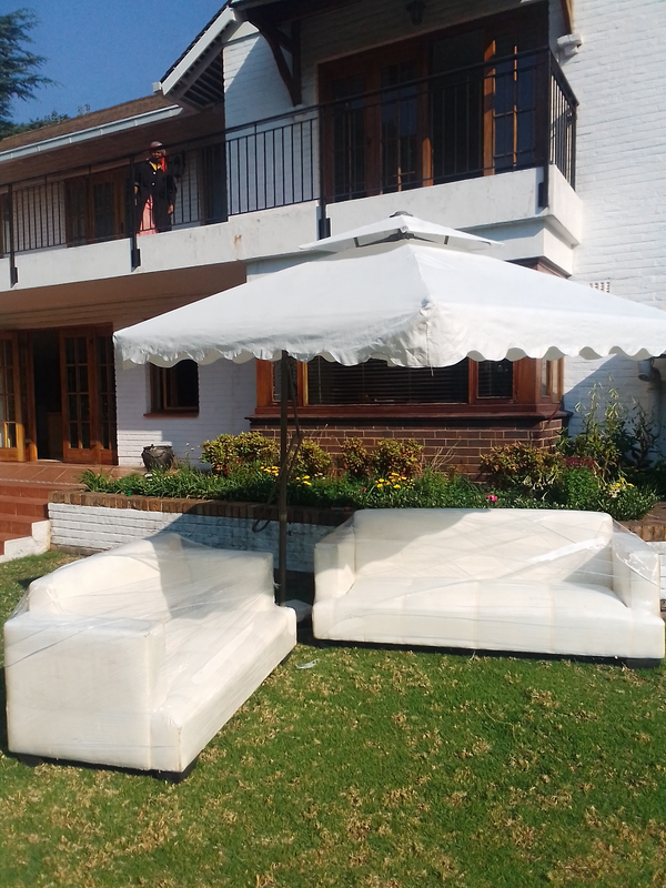 Garden umbrellas and white VIP couches hire and decor