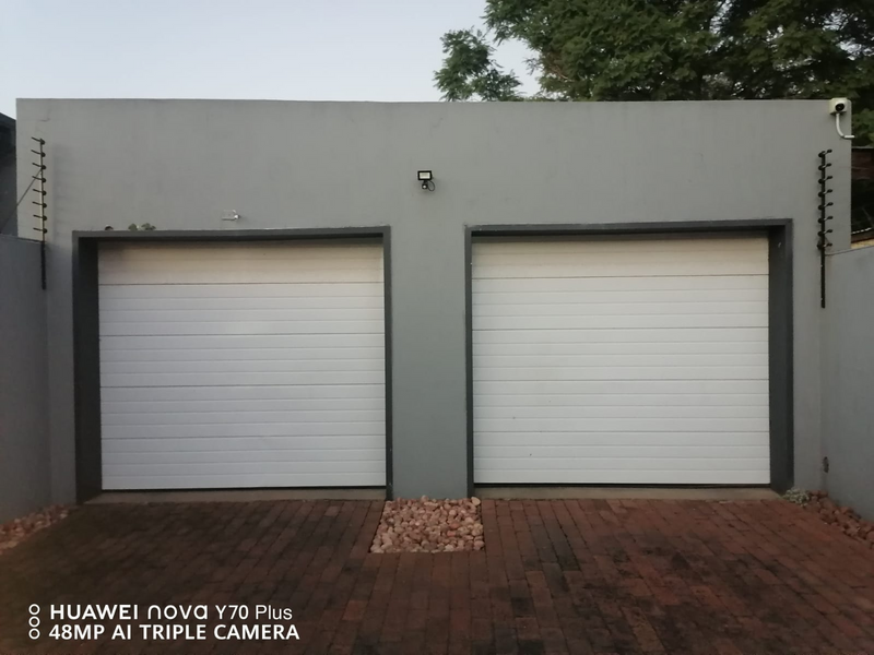 Two white garage doors and two Lotex motors with all fittings