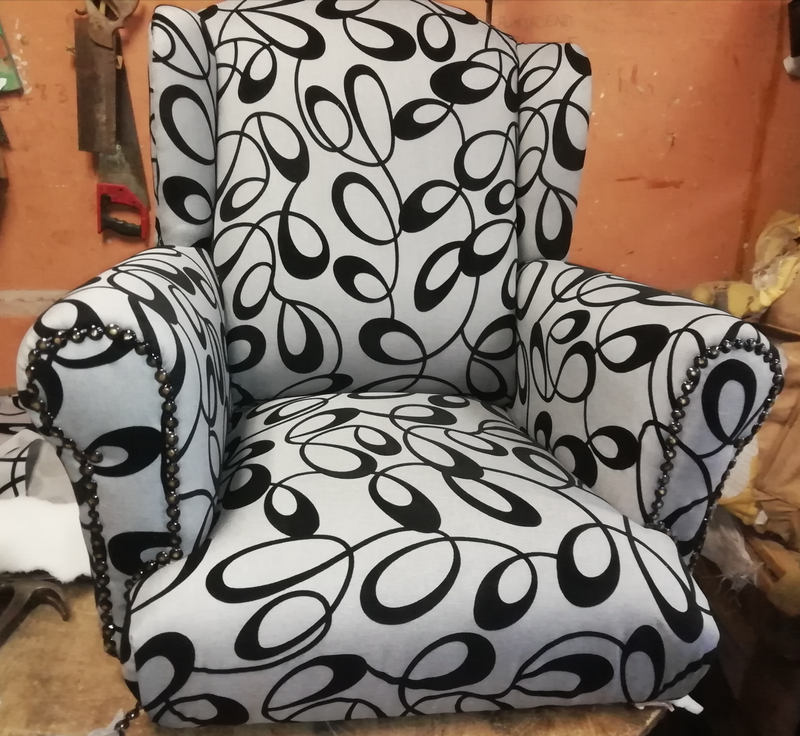 Black and light grey wingback chair. Quite a big chair. Plated with antique studs