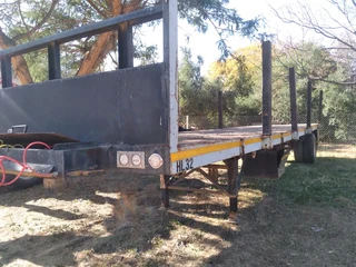 1990 12m flatdeck extendable trailer with up rights.