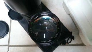 Camera bean bag, vintage lens and 35mm film reel