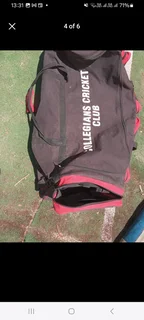 Pull along cricket kit bag with cricket items including set of DP pads and cricket bat
