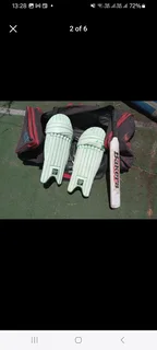 Pull along cricket kit bag with cricket items including set of DP pads and cricket bat