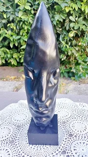 Vintage charcoal-black abstract face mask sculpture on base. Signed.