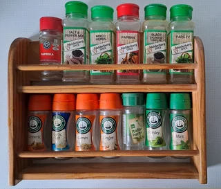 Wooden shelf for spices. Two tier. With empty glass and plastic bottles.