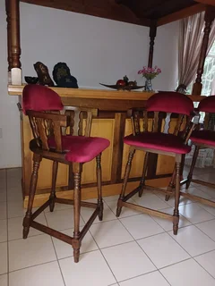 Imbuia and yellowwood L-shape home bar with upholstered chairs