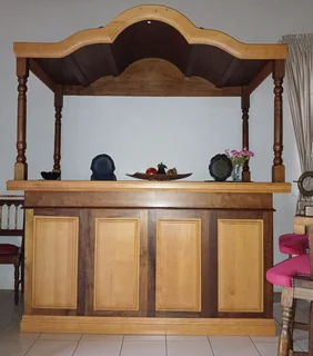 Imbuia and yellowwood L-shape home bar with upholstered chairs