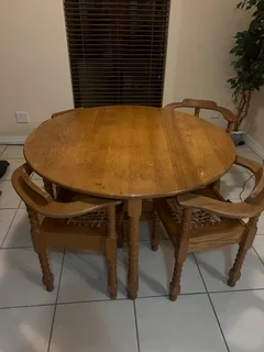 A yellowwood table and 4 chairs as well as a yellowwood 3-door cabinet