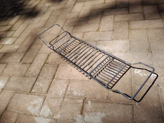 Stainless steel bath caddy fits across the bath to keep soap, cosmetics