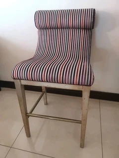 A brand new designer high quality bar chair with brass foot rest.