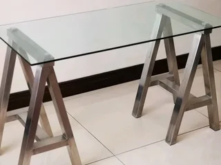 Glass table on heavy metal trusses, made with quality material. Dimensions are W126/H77/D60