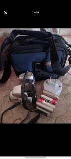 Minolta camera with bag, batteries and battery charger.
