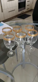 Sets of variety of vintage wine glasses with a gold rim and glasses
