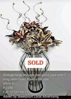 Vintage large wrought iron glass vase with 7 long stem brass flowers for sale.