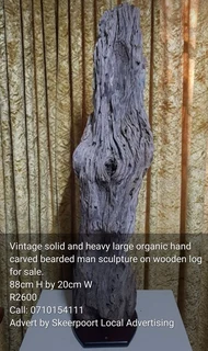 Vintage solid and large organic hand carved bearded man sculpture on wooden log for sale