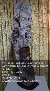 Vintage solid and large organic hand carved bearded man sculpture on wooden log for sale