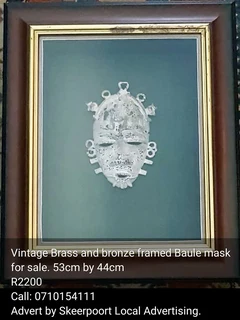 Vintage brass and bronze framed Baule mask for sale.