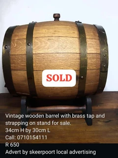 Vintage wooden barrel with brass tap and strapping on stand for sale.