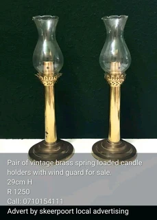 Pair of vintage brass spring loaded candle holders for sale.