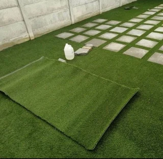 Artificial synthetic grass and brown decorative stones