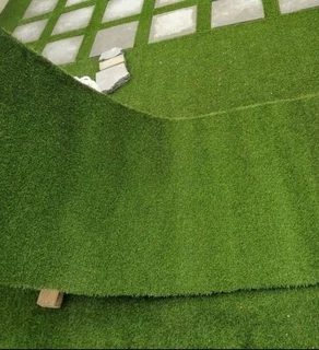 Artificial synthetic grass and brown decorative stones