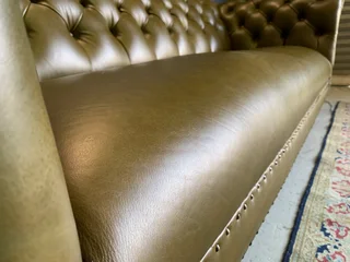 A classic 2.1m olive green genuine leather Chesterfield three seater sofa. (A VINTAGE COLLECTION)