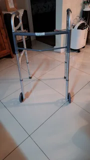 Fold up assisted walker.  Aluminum with wheels.
