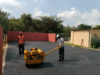 Tar surfacing and brick paving