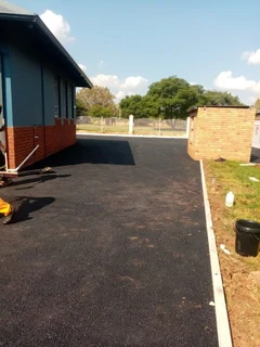 Tar surfacing and brick paving