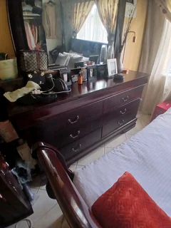 A queen size sleigh bedroom suit  with two pedestals and chest of drawers with a mirror.