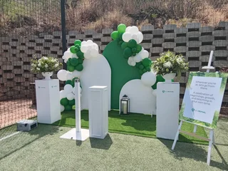 Outdoor Chillas decor. Umbrellas with Couches, Ottomans, Cocktails and Artificial green carpet.