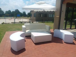 Outdoor Lounge set up. Garden Umbrellas hire, White couches mix with Cocktails set up.
