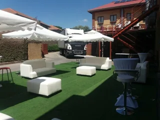 Outdoor furniture hire. White couches or pallets chillas decor set up. Garden Umbrellas hire.