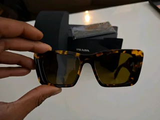 Brand new authentic Prada sunglasses in tortoiseshell frame with dark brown lenses.