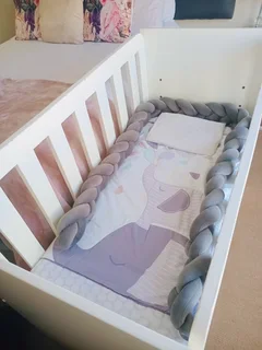 White wooden baby cot with storage